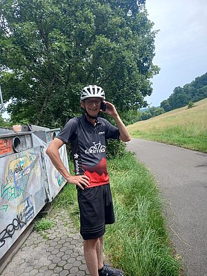 Mann mit Fahrradhelm am telefonieren